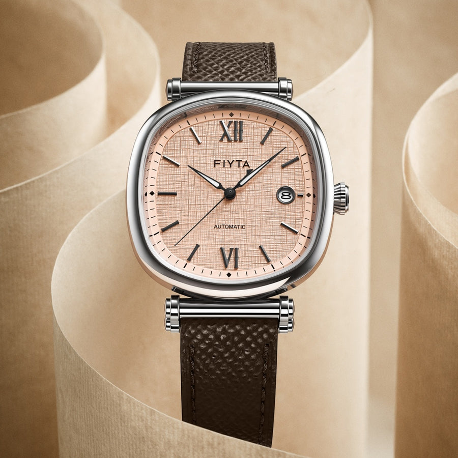 The FIYTA Tempered watch with a rose-toned textured dial and brown strap displayed upright on a beige surface. (GA850028.WOK)