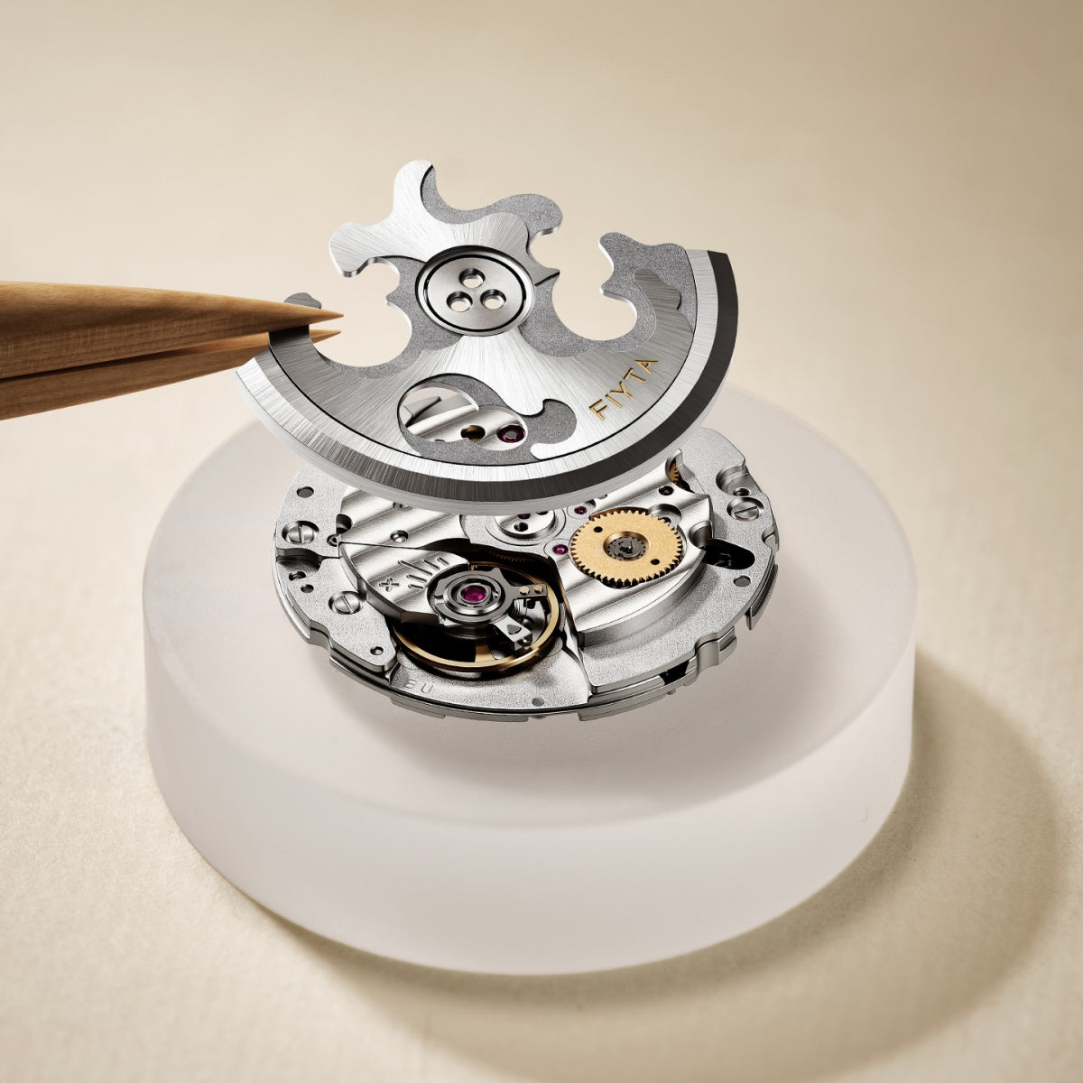 A FIYTA watch movement displayed with its rotor lifted above the mechanism and a wooden tool beside it.